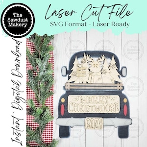 Peut inclure: Décoration de Noël en bois découpée au laser en forme de camion, avec un orignal et des arbres dans la benne. Le camion est bleu foncé avec des feux arrière rouges et le texte "MERRY CHRISTMOOSE" et "COZY". L'image comprend également le texte "Laser Cut File" et "Instant Digital Download".
