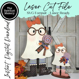 May include: Two laser-cut wooden ghost figures featuring orange polka-dot bows, brown round glasses, and striped leggings. Each ghost wears dark boots and holds a purple and orange lollipop with a tag that reads BOO. Text includes Laser Cut File.