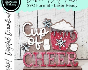 May include: A wooden sign with the words "Cup of Cheer" in red letters. The sign features a red mug with white marshmallows and a snowflake design. The mug is filled with a brown liquid and topped with whipped cream. The sign is perfect for a winter or holiday theme.