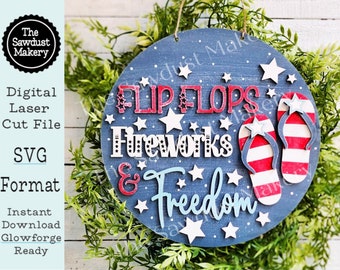 May include: A round wooden sign with a blue background and white stars. The sign says "Flip Flops, Fireworks & Freedom" in red, white, and blue lettering. There are two red, white, and blue flip flops on the sign.