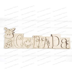 May include: Wooden cutout of the word "CANADA" with a moose, maple leaf, and other decorative elements.
