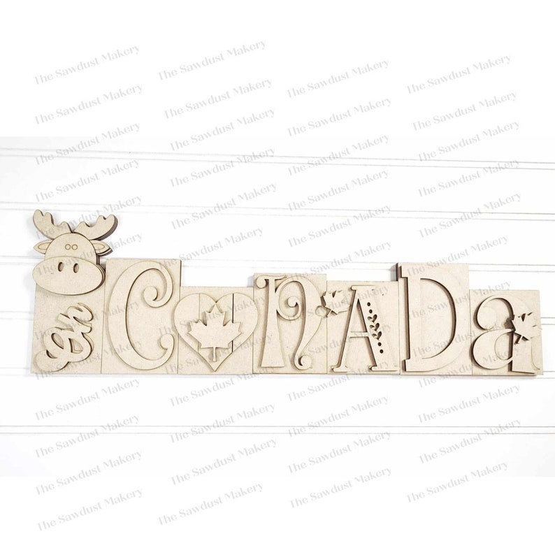 May include: Wooden cutout of the word "CANADA" with a moose, maple leaf, and other decorative elements.