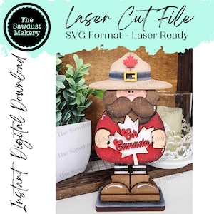 May include: Laser cut file for a wooden figurine of a Canadian Mountie holding a red maple leaf with the words "Oh Canada" on it. The figurine is wearing a brown hat with a red maple leaf on it and a red jacket with white stripes.
