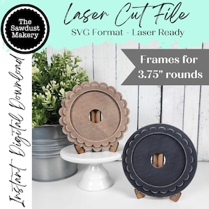 May include: Two laser cut wood frames for 3.75 inch round items. The frames are shown on a white pedestal and a gray metal surface. One frame is brown and the other is black.