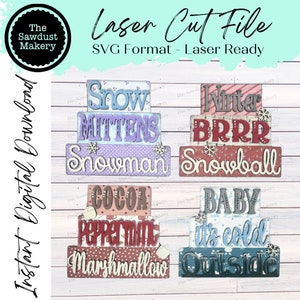 May include: Four sets of layered wooden signs with winter-themed words. The first set reads "Snow Mittens Snowman", the second set reads "Winter BRRR Snowball", the third set reads "Cocoa Peppermint Marshmallow", and the fourth set reads "Baby It's Cold Outside".