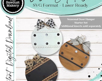 May include: A digital file for a laser cut seasonal door hanger starter set. The image displays three circular wooden ornaments in white, brown, and black, each featuring decorative bows, polka dots, and horizontal bands for interchangeable inserts.