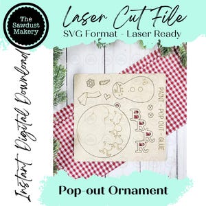 May include: A laser-cut wooden pop-out ornament with a snowman, girl, and letter designs. The text "Laser Cut File" and "SVG Format - Laser Ready" are visible. The words "Instant Digital Download" and "Pop-out Ornament" are also present.