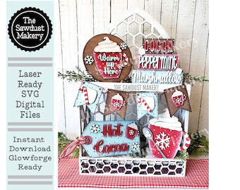 May include: A set of laser-cut wooden Christmas decorations featuring a hot cocoa theme. The set includes a banner, a mug, a tag, and three stacked signs that read "Cocoa Peppermint Marshmallow". The decorations are painted in red, white, and brown with a rustic, farmhouse style.