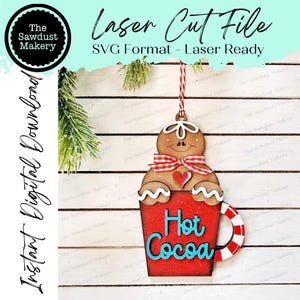 May include: A wooden Christmas ornament depicting a gingerbread man in a red mug of hot cocoa. The ornament has a red and white striped ribbon, and the words "Hot Cocoa" are written in blue. The text "Laser Cut File" is also visible.