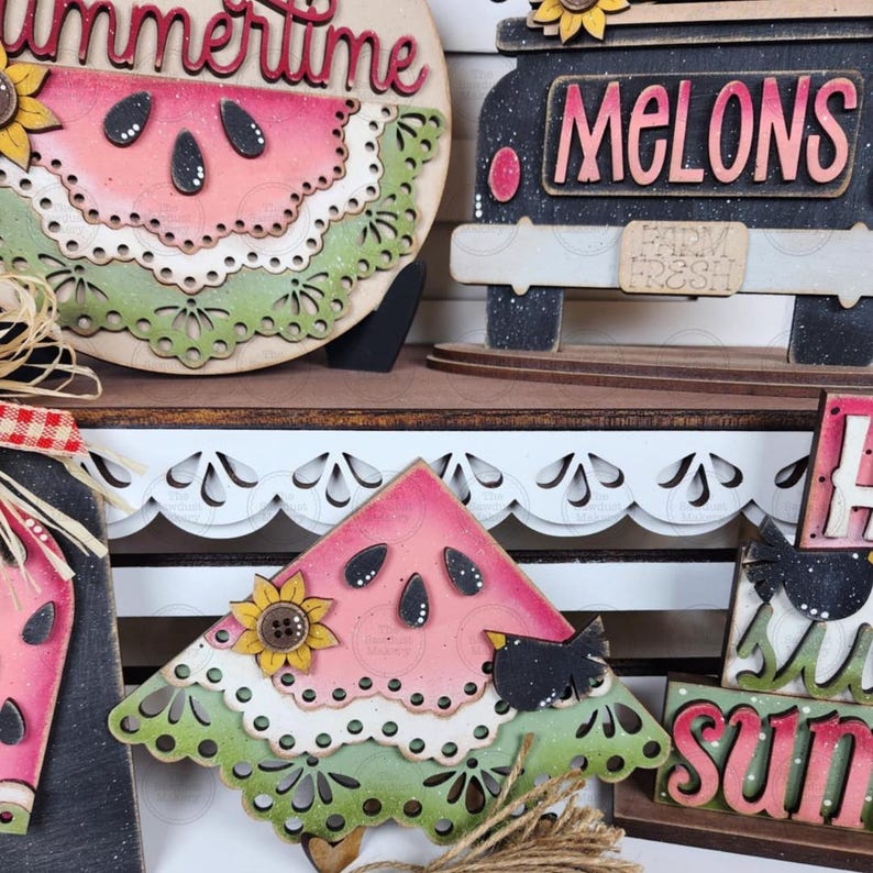 May include: Wooden watermelon-themed decorations with a summer theme. The decorations include a watermelon slice, a truck with the word "Melons", and the word "Summertime". The watermelon slice has a sunflower and a black bird.