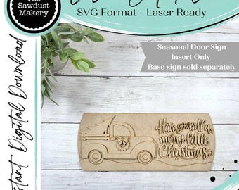 May include: A laser-cut wooden sign insert featuring a truck carrying a Christmas tree and the text Have yourself a merry little Christmas. The design includes a wreath on the truck door and is intended for a seasonal door sign base.