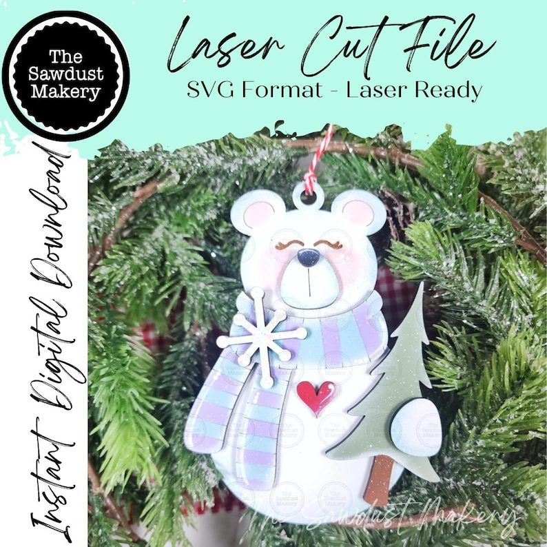 May include: A laser cut file digital download featuring a white bear ornament with a blue and purple striped scarf, a white snowflake, a red heart, and a green pine tree. The text reads Laser Cut File, SVG Format - Laser Ready, and Instant Digital Download.