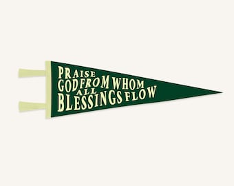 Puede incluir: Un banderín verde oscuro con el texto "PRAISE GOD FROM WHOM ALL BLESSINGS FLOW" en letras color crema. El banderín tiene tela color crema en la parte superior para colgar.