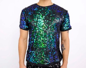 May include: A person wearing a black sequin t-shirt with blue and green accents, paired with black sequin shorts. The outfit is a shimmering ensemble, perfect for a party or performance. The t-shirt has short sleeves and a crew neck.
