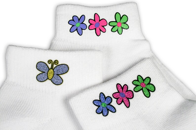 May include: A pair of white ankle socks with colourful embroidered flowers and a butterfly. The socks have a ribbed texture.