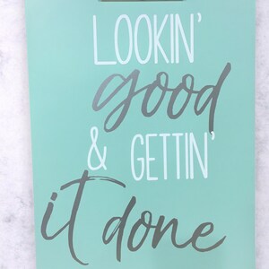 Op de afbeelding: Een lichtblauw clipboard met de tekst "LOOKIN' good & GETTIN' it done" in witte en grijze letters.