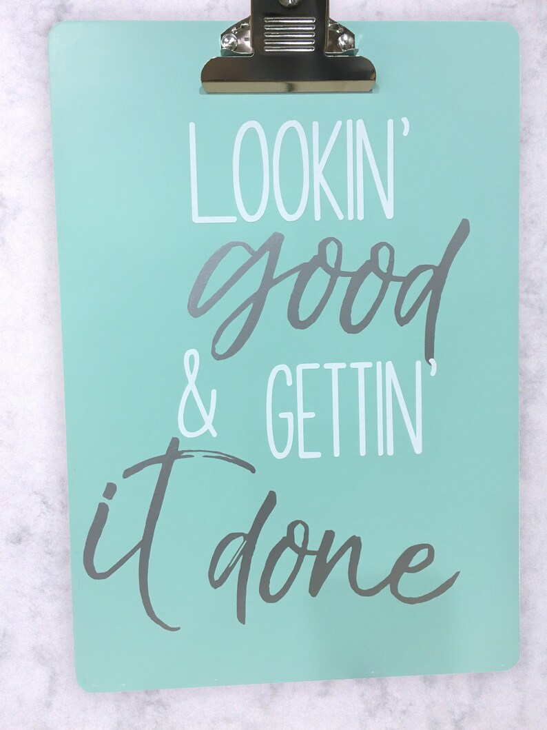 Op de afbeelding: Een lichtblauw clipboard met de tekst "LOOKIN' good & GETTIN' it done" in witte en grijze letters.