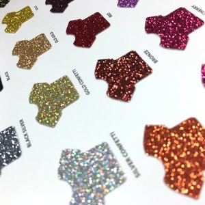 May include: A close-up of a color chart showing different glitter colors. The colors include black, black silver, gold confetti, red, bronze, cherry, copper, and more.