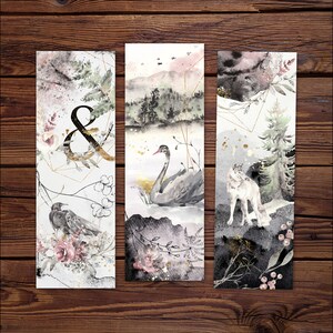 May include: Three rectangular bookmarks featuring watercolor illustrations. The first shows a crow, flowers, and an ampersand. The second depicts a black swan on water with mountains. The third displays a wolf in a forest. All include gold geometric lines.
