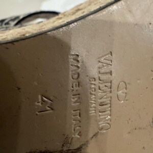 May include: Close-up of the sole of a shoe. The shoe is marked "VALENTINO GARAVANI" and "MADE IN ITALY". The size is marked as "41". The sole is a light brown color.