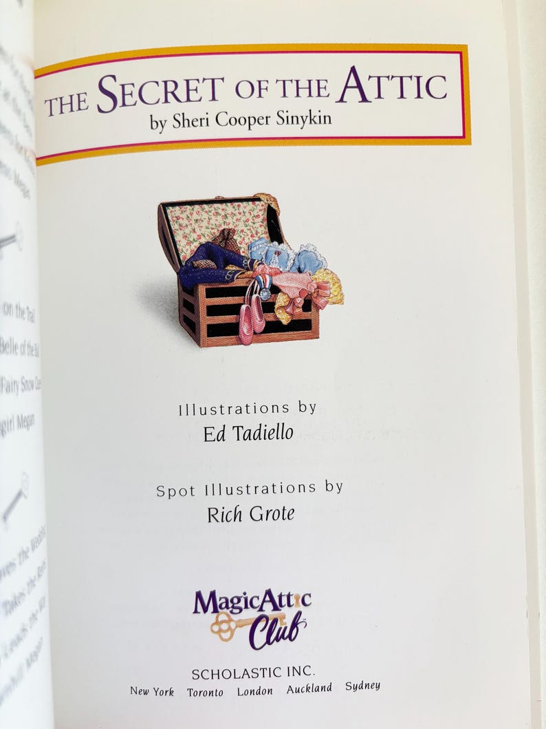May include: The title page of the book The Secret of the Attic by Sheri Cooper Sinykin. It features an illustration of an open wooden chest filled with colorful clothing and accessories, with credits for Ed Tadiello, Rich Grote, and the Magic Attic Club.
