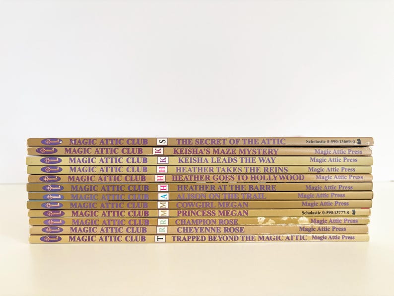 May include: A stack of eleven Magic Attic Club books with tan spines and purple text. Titles include The Secret of the Attic, Keisha's Maze Mystery, Keisha Leads the Way, Heather Takes the Reins, Heather Goes to Hollywood, Heather at the Barre, Alison on the Trail, Cowgirl Megan, Princess Megan, Champion Rose, Cheyenne Rose, and Trapped Beyond the Magic Attic.
