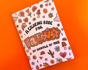May include: A coloring book with a pink cover and the text "A Coloring Book for Taurus" in black and gold lettering. The cover is decorated with colorful doodles of hearts, stars, flowers, and other whimsical designs.