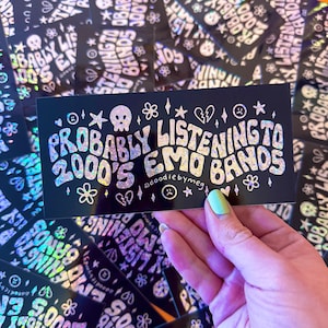 May include: A black and white sticker with iridescent glitter that says "Probably Listening to 2000's Emo Bands" with a skull and other small graphics.