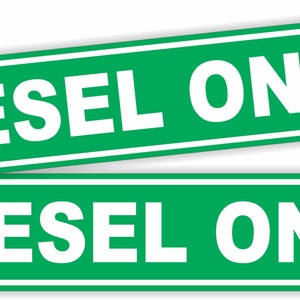 May include: Two green signs with white text that reads "DIESEL ONLY".