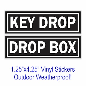 May include: Two black rectangular stickers with white text. The top sticker reads "KEY DROP" and the bottom sticker reads "DROP BOX". The stickers are 1.25" x 4.25" and are vinyl and weatherproof.