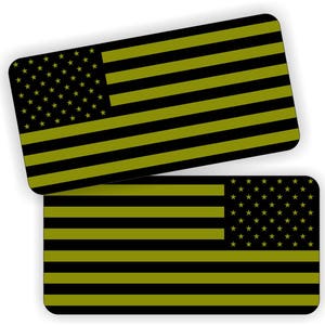 May include: Two black and olive green American flag stickers. The flags are in a horizontal orientation. The top flag has a white star field and the bottom flag has a white star field on the right side.