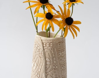 white ceramic vase with floral ornament