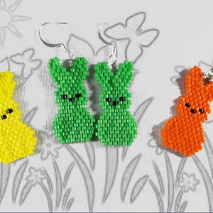 May include: A pair of green, yellow and orange bunny-shaped earrings. The earrings are made of small beads and are strung together to form the shape of a bunny. The earrings are hanging from silver hooks.