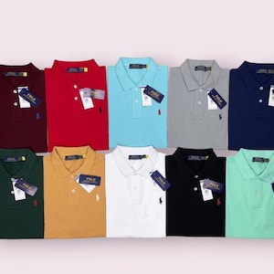 Puede incluir: Una colección de diez polos de manga corta en varios colores sólidos, incluyendo burdeos, rojo, azul claro, gris, azul marino, verde oscuro, beige, blanco, negro y verde menta. Cada polo cuenta con cuello, tapeta de botones y un logo de Polo Ralph Lauren.