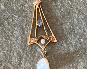 May include: A gold pendant with a geometric design, accented with pearls and a blue gemstone. A single pearl dangles from the bottom.