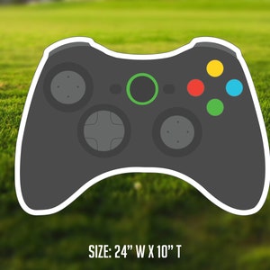 May include: A black and gray video game controller with green, red, yellow, and blue buttons. SIZE: 24" W x 10" T