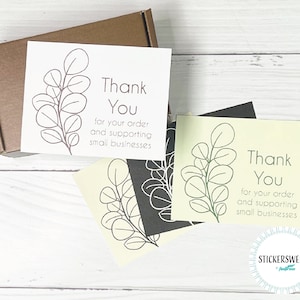 May include: Three thank you cards with a simple line drawing of a eucalyptus branch. The cards are printed on white, black, and yellow paper. The text on the cards reads "Thank You for your order and supporting small businesses".