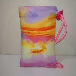 May include: A small drawstring bag with a sunset-colored print. The bag is made of fabric and has a pink drawstring.