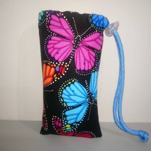 May include: A small black drawstring bag with a blue cord. The bag is decorated with a colorful butterfly pattern.