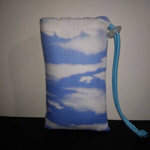 May include: A small blue drawstring bag with a white cloud pattern. The bag has a blue drawstring and a white plastic toggle.