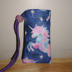 May include: A small blue drawstring bag with a unicorn and stars print. The bag has a purple drawstring.