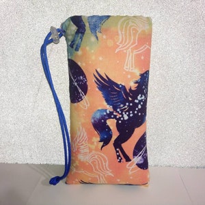 May include: A drawstring bag with a colorful print of flying horses and planets on a peach background. The bag has a blue drawstring.