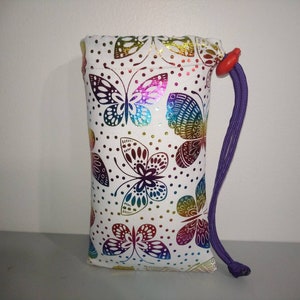 May include: White drawstring bag with a colorful butterfly pattern and a purple drawstring.