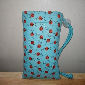 May include: A light blue drawstring bag with a ladybug print. The bag has a white drawstring closure and a light blue cord.