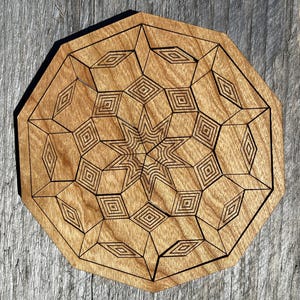 May include: A wooden geometric design with a star in the center. The design is laser cut and has a brown wood finish.