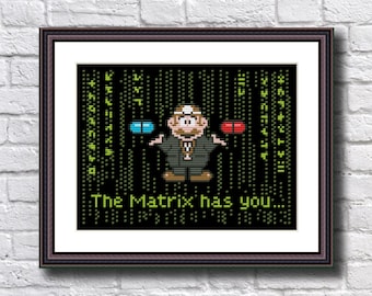 May include: A cross-stitch pattern featuring a pixelated character from the movie The Matrix holding a blue and a red pill. The background is a black screen with green code. The text "The Matrix has you..." is below the character.