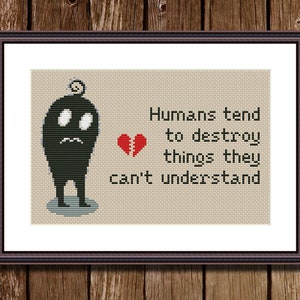 Puede incluir: Un diseño de punto de cruz en blanco y negro que representa una criatura negra de aspecto triste con un pequeño pájaro en la cabeza. El texto "Humans tend to destroy things they can't understand" está debajo de la criatura.