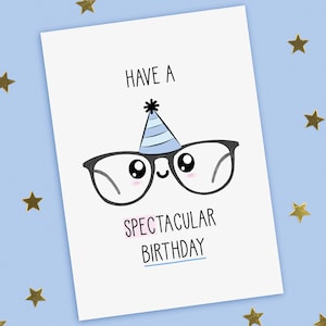 A funny birthday card with a hand drawn image of a black framed pair of glasses with big eyes and wearing a blue party hat with pale blue stripes. The card caption is: Have A Spectacular Birthday