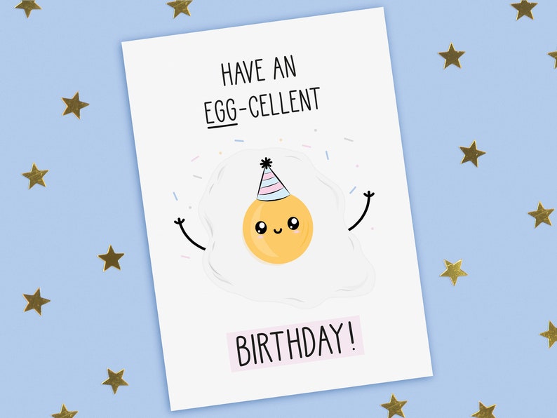 A funny birthday card with a hand drawn image of a fried egg (sunny side up) wearing a party hat with blue and pink stripes. It is throwing confetti. The card caption is: Have An Egg-Cellent Birthday