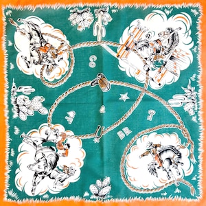 K&ouml;nnte beinhalten: Quadratisches Bandana mit gr&uuml;nem Mittelteil und orangefarbenem Rand. Das Design zeigt Cowboys, die auf wilden Pferden reiten, Kakteen und ein Seilmuster. Die Buchstaben "CO", "Q" und "BR" sind ebenfalls sichtbar.